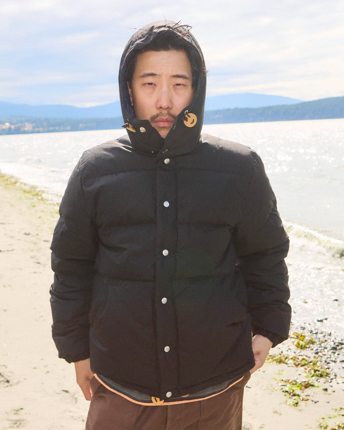 Black down sweater puffer jacket with hood made from dry wax cotton