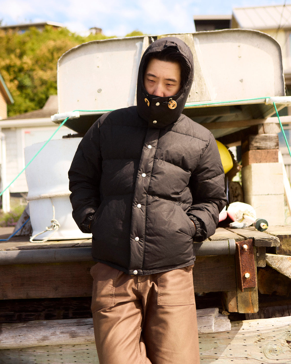Black down sweater puffer jacket with hood buttoned front made of dry wax cotton for cold weather