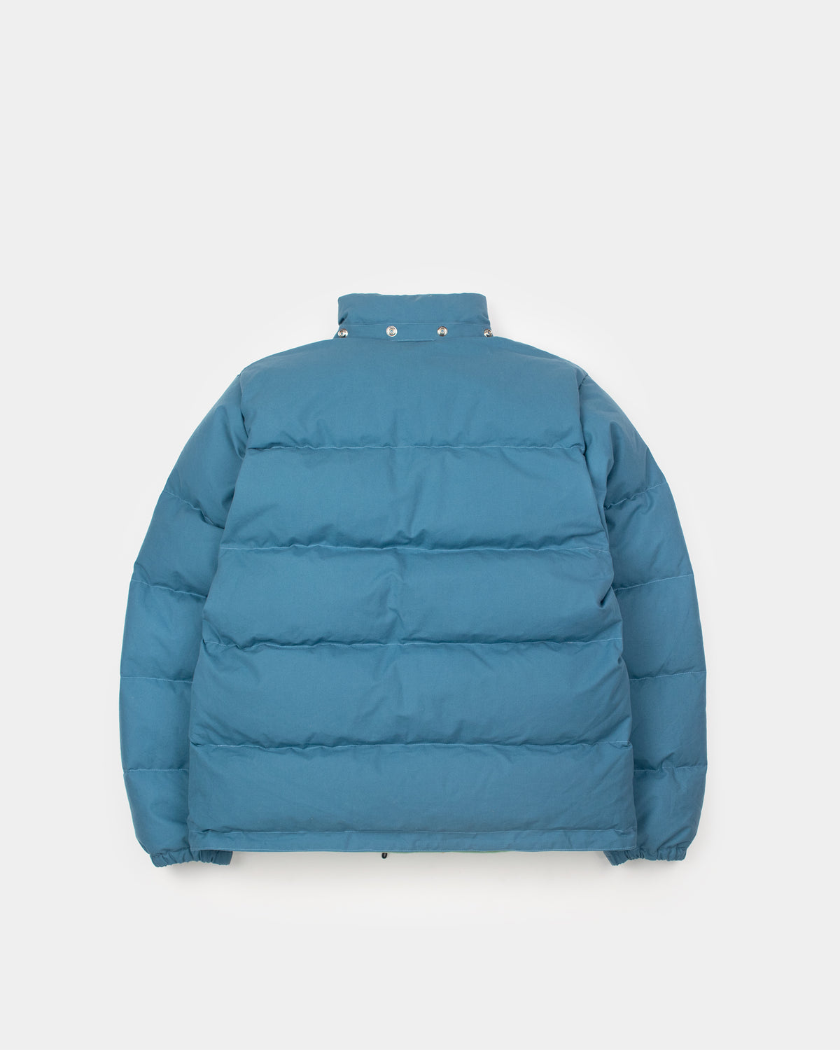 Puffer down sweater in robin's blue with horizontal stitching silver snap buttons at the collar made of dry wax cotton