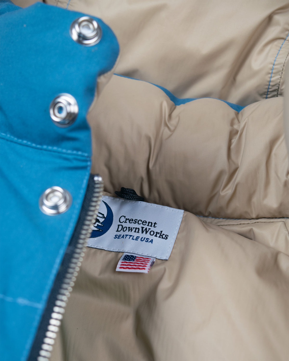 Robin's Blue down sweater puffer jacket with silver snap buttons made of dry wax cotton featuring crescent downworks label