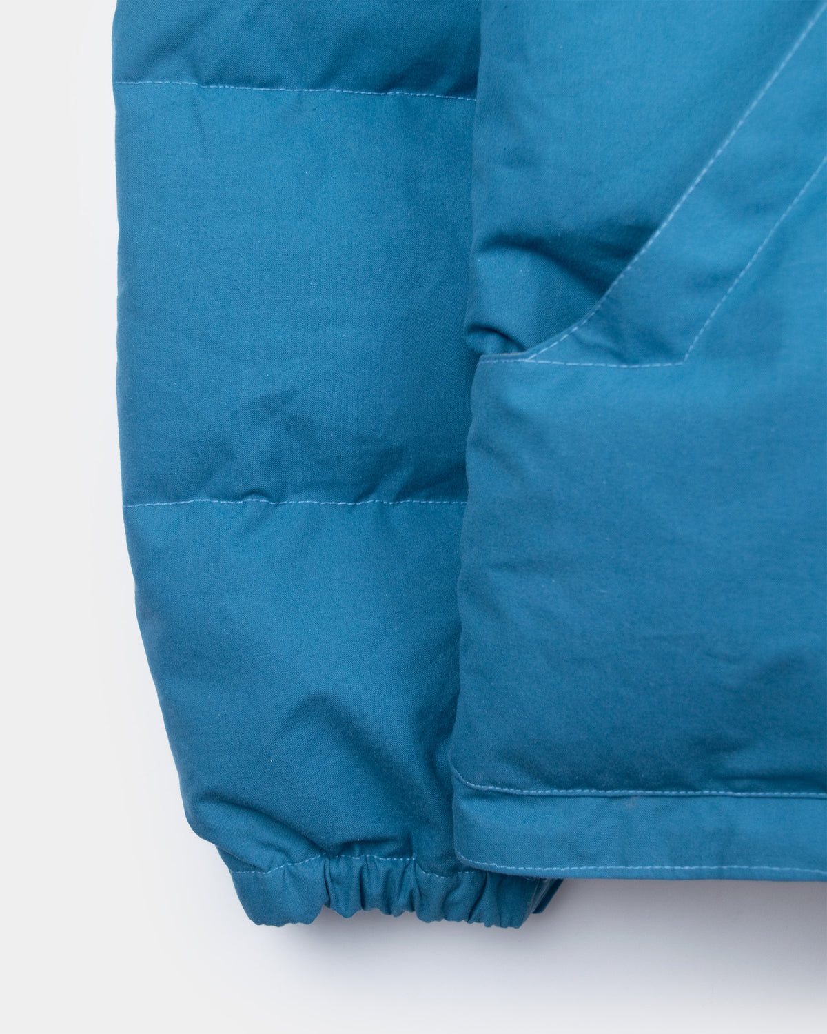 Robin's blue down sweater sleeve with quilted stitching and elasticated cuff made from dry wax cotton
