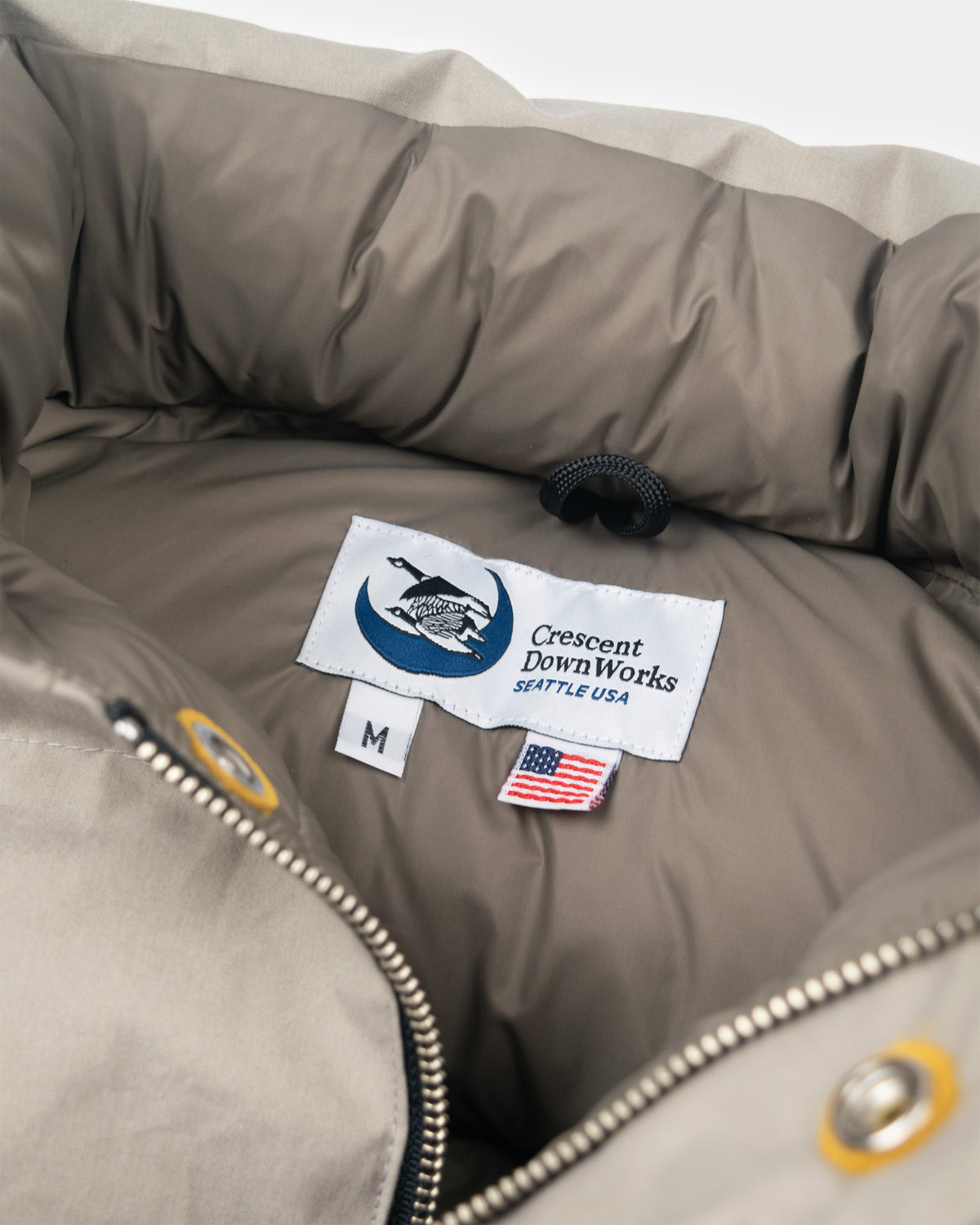 Stone down sweater puffer jacket in dry wax cotton with crescent downworks logo and american flag tag on white label