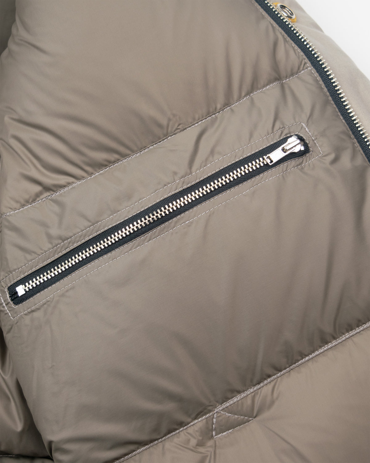 Down sweater puffer jacket in dry wax cotton stone with black zipper and silver metal pull