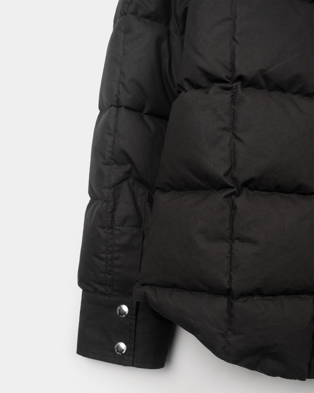 Black down shirt made of dry wax cotton with quilted panels and silver-toned snap buttons on sleeve cuff