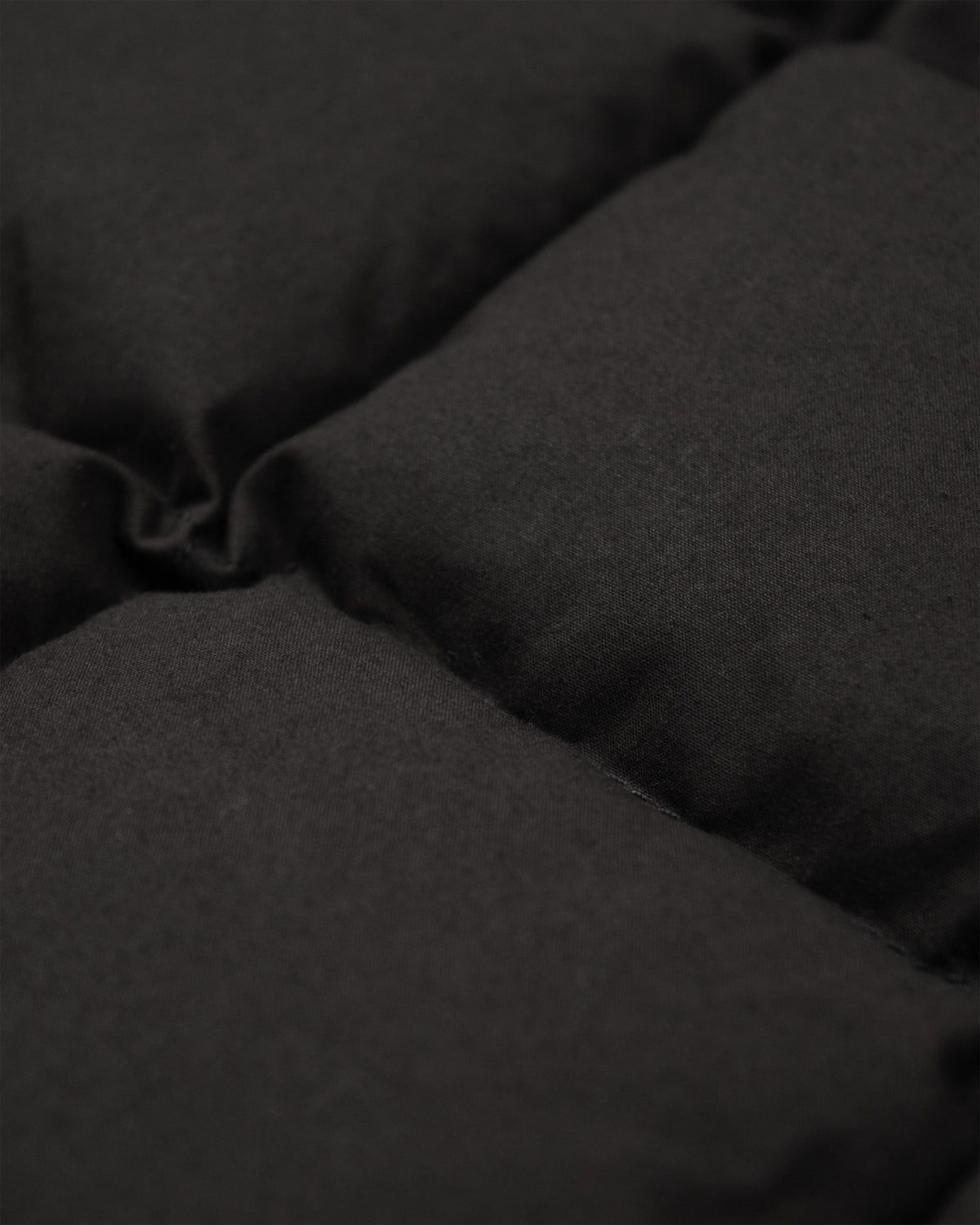Black quilted dry wax cotton fabric with soft texture and visible stitching on down shirt black