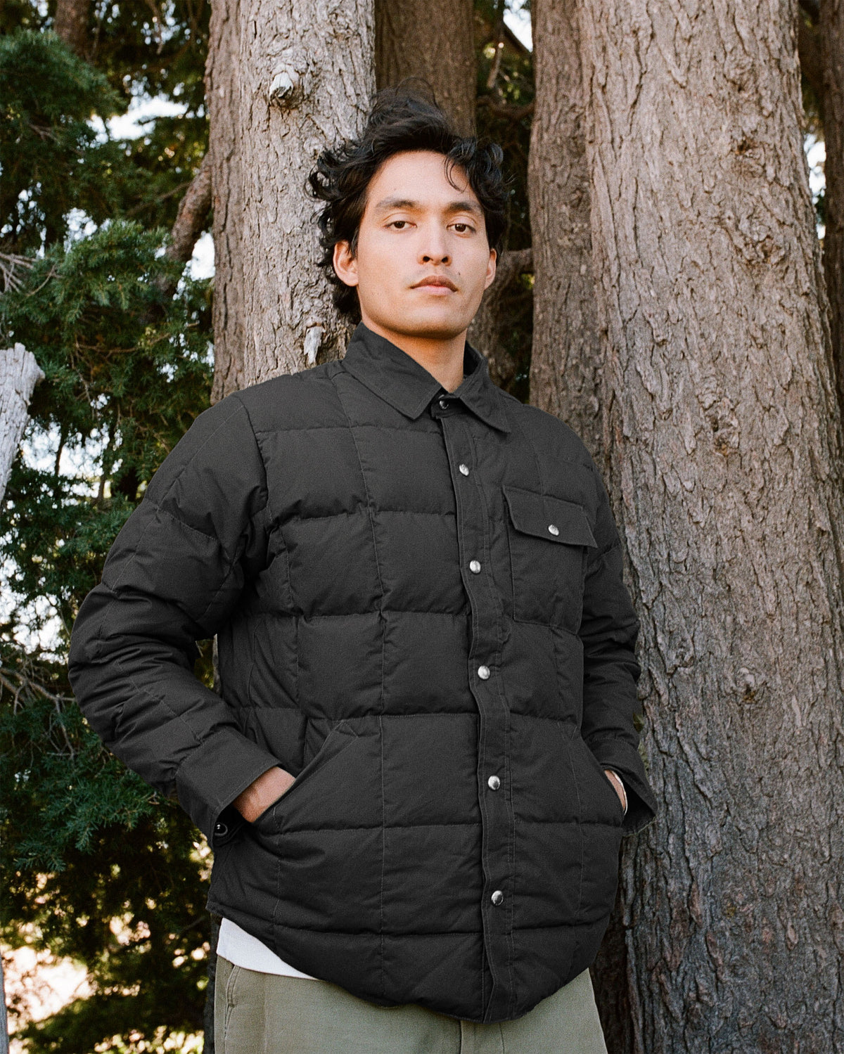 Black quilted down shirt jacket with silver buttons and two front pockets made from dry wax cotton