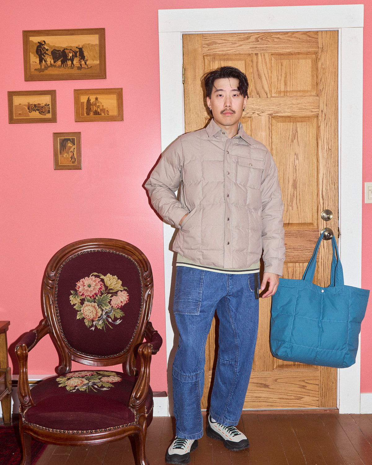 Blue quilted tote bag made of dry wax cotton shown with down shirt in stone color for durable everyday use