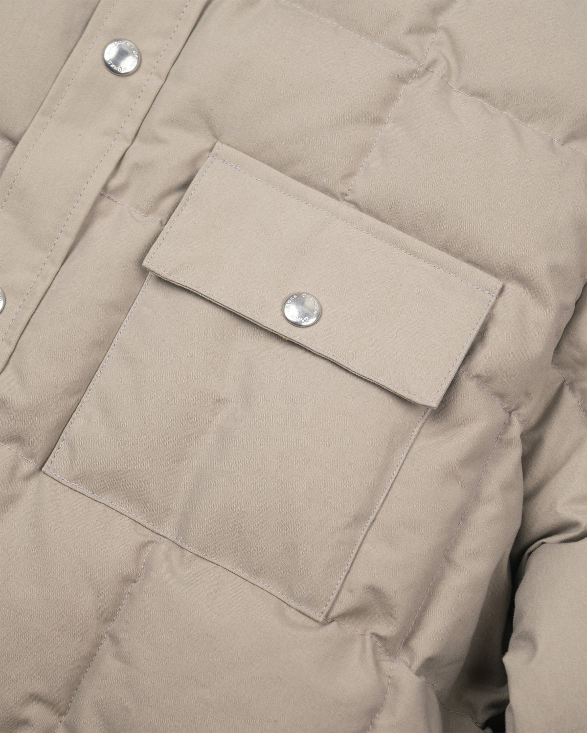 Stone down shirt made of dry wax cotton with quilted texture and silver-toned snap buttons in stone color
