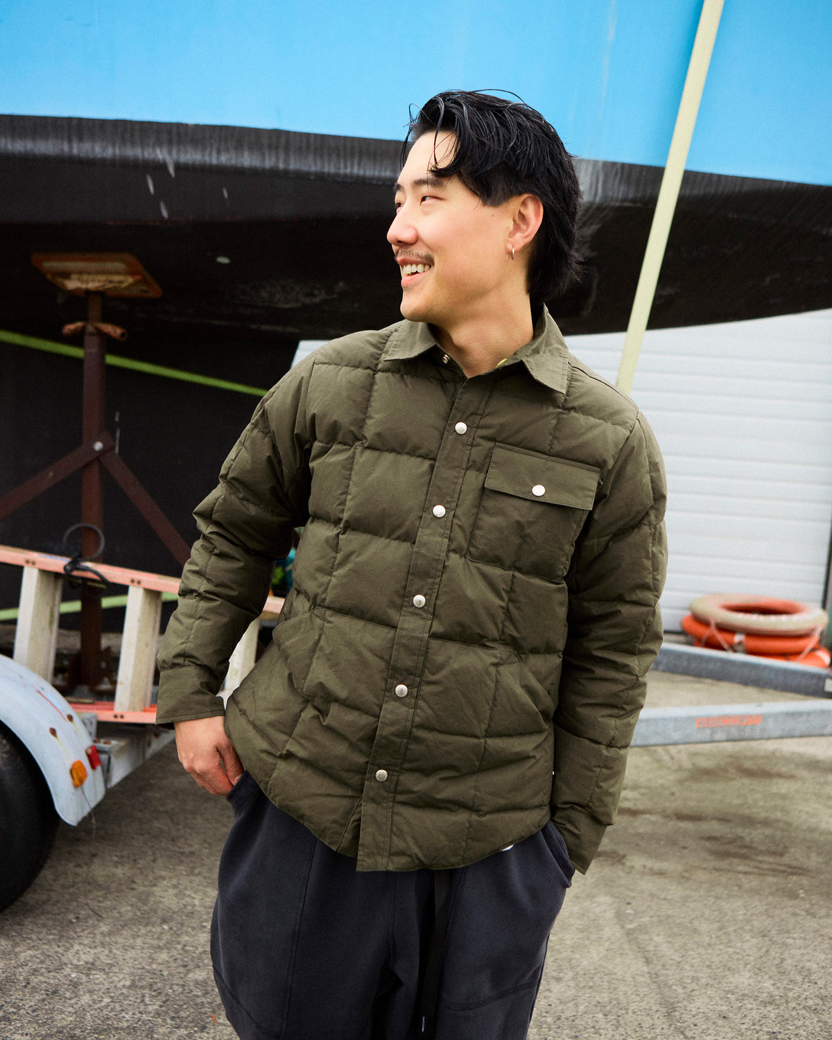 Olive green quilted button-up down shirt jacket in dry wax cotton for outdoor use with tent design details