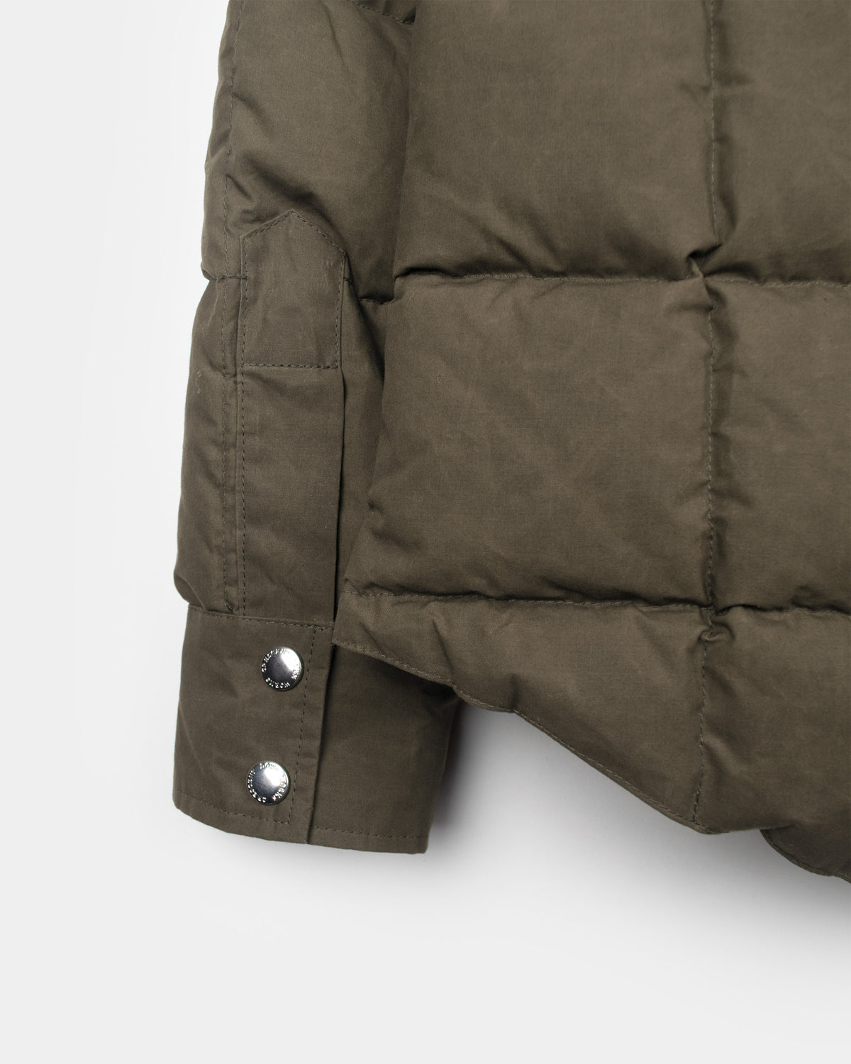 Olive green quilted sleeve of down shirt dry wax cotton with silver-toned snap buttons in tent color