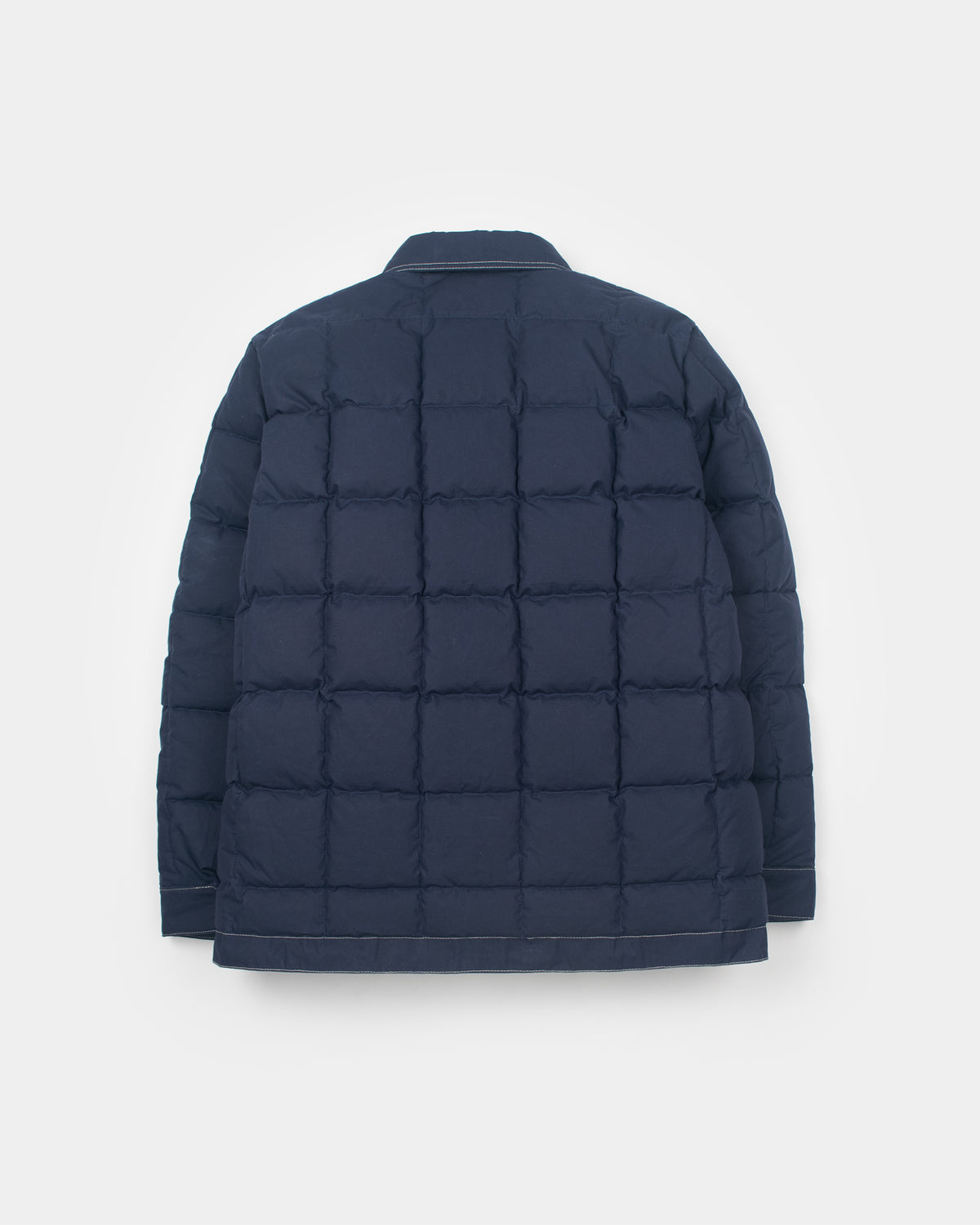 A dark navy blue quilted down chore coat jacket shown from the back, photographed against a clean, light gray studio background.