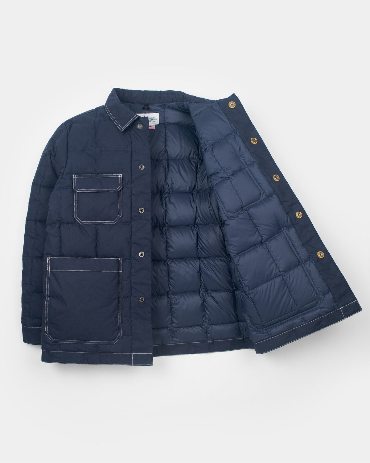 A navy blue down chore coat quilted jacket shown open to display both the exterior front and the padded interior lining, laid flat against a light gray background.
