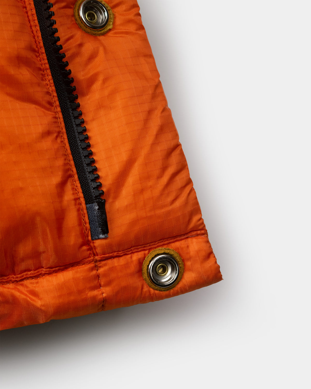 Bright orange down italian vest in ripstop nylon with black zipper and brass snap buttons on front