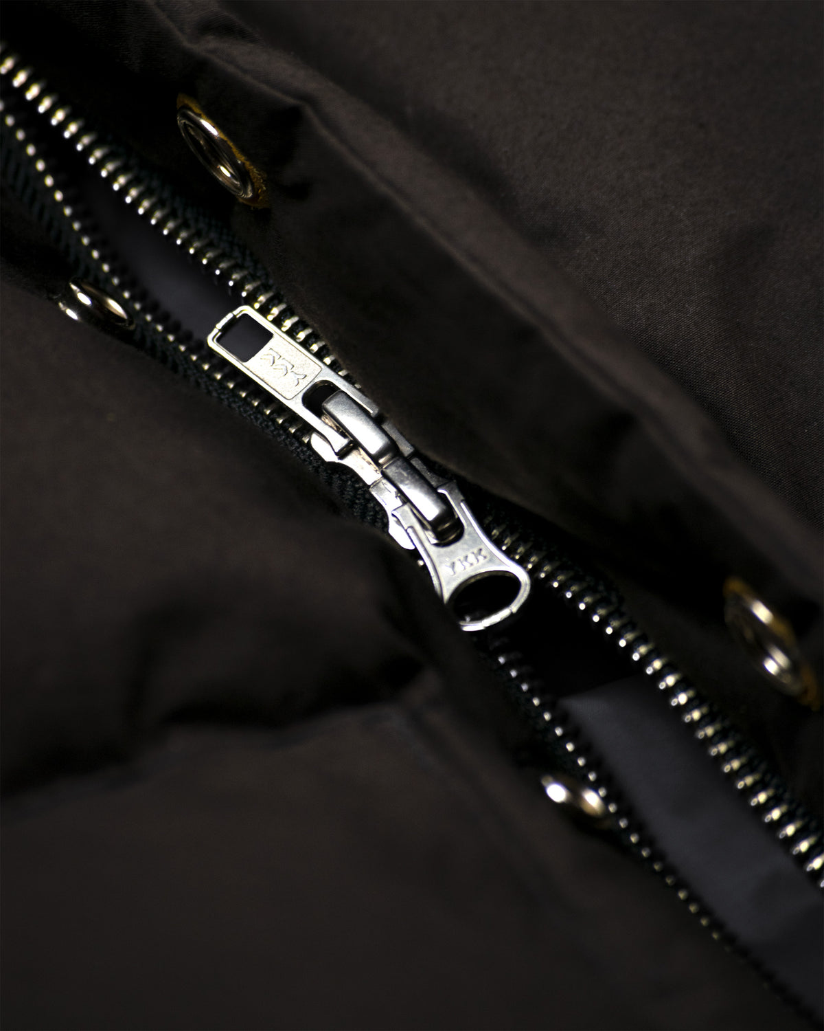 Silver-toned metal zipper detail on black down italian vest made from dry wax cotton fabric