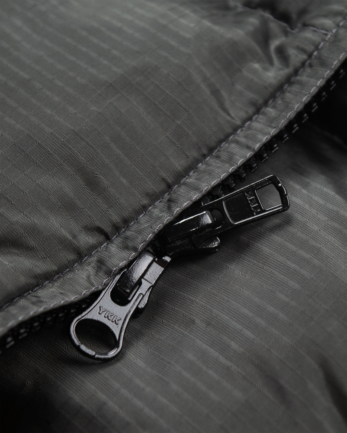 North by northwest vest in charcoal ripstop nylon with black matte ykk nylon zipper pull tab  name