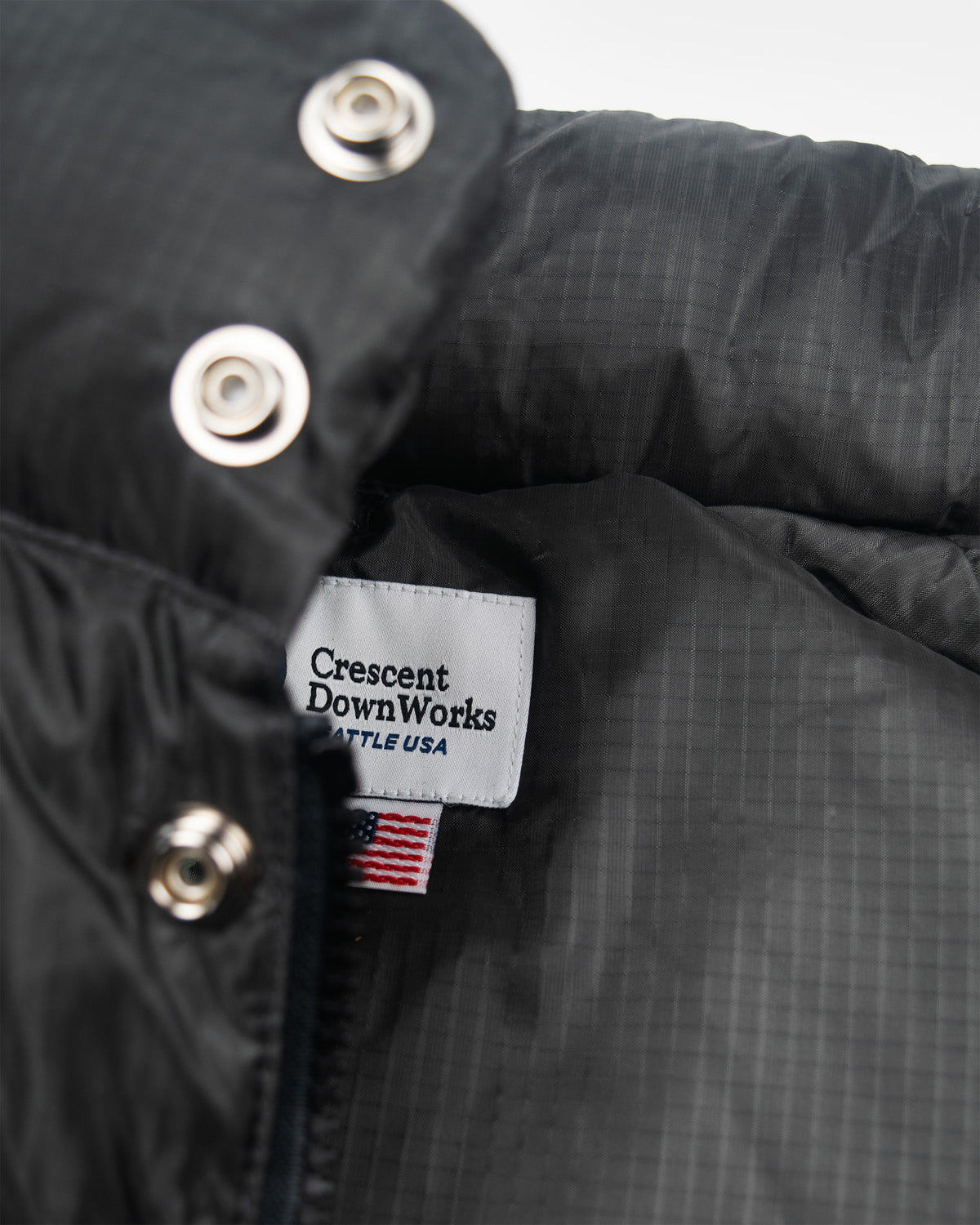 Classico down parka in charcoal black ripstop nylon with silver snap buttons and subtle grid pattern on fabric