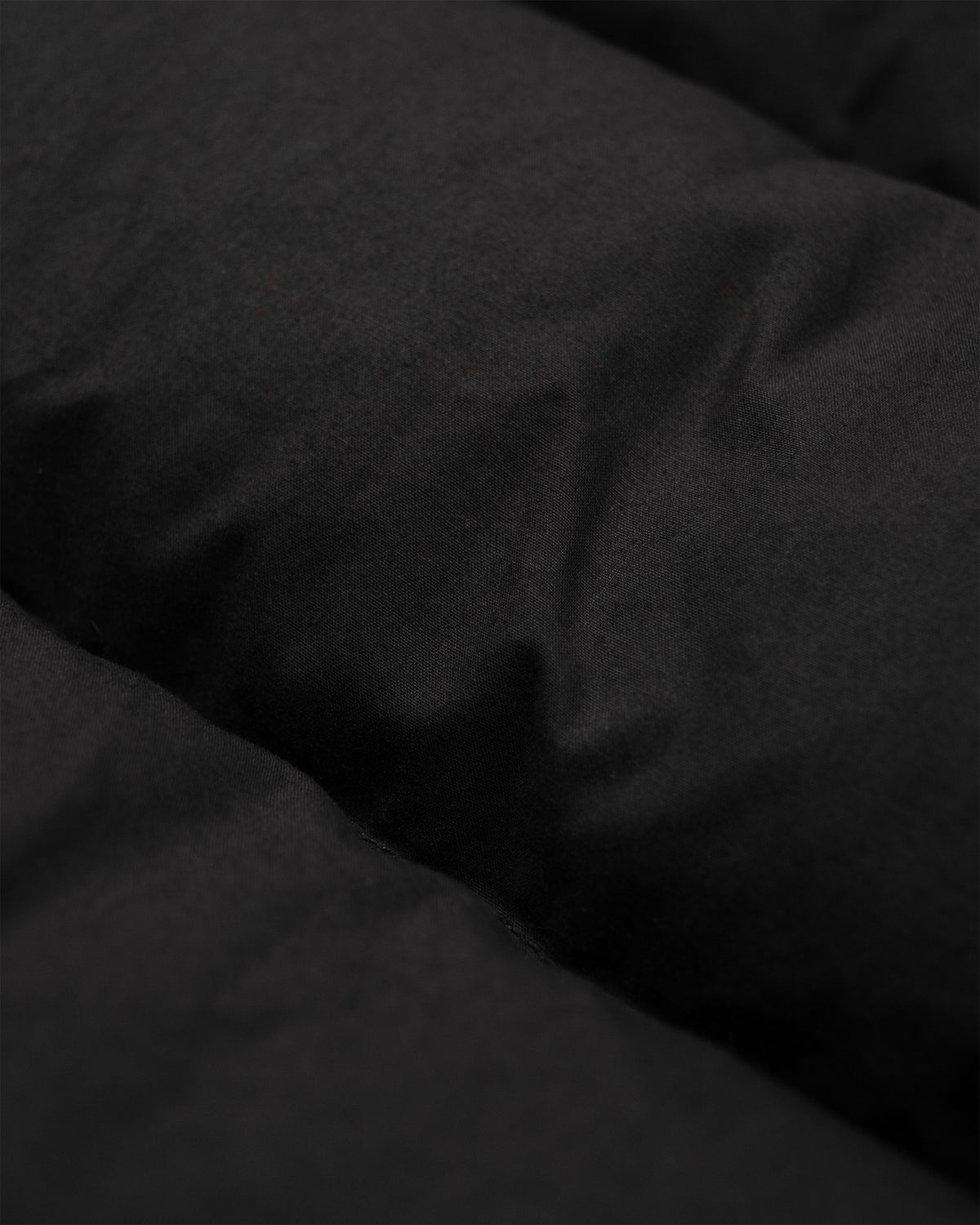 Black quilted fabric with soft plush texture on classico down parka made from dry waxed cotton in black
