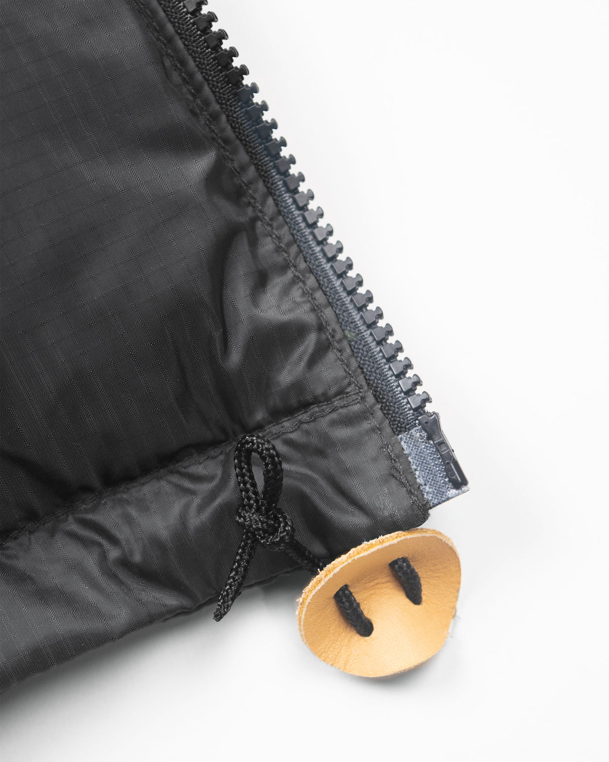 Hooded sweatshirt in charcoal ripstop nylon with a black puffer jacket style zipper and leather toggle