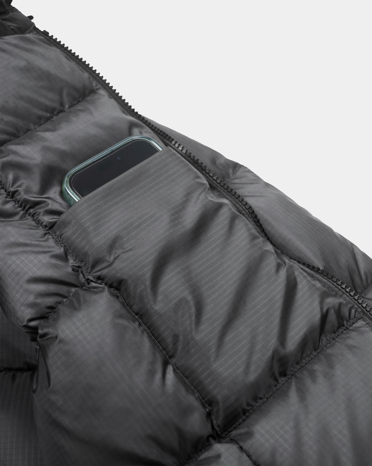 Black hooded sweatshirt in charcoal ripstop nylon with quilted puffer design and zippered phone pocket