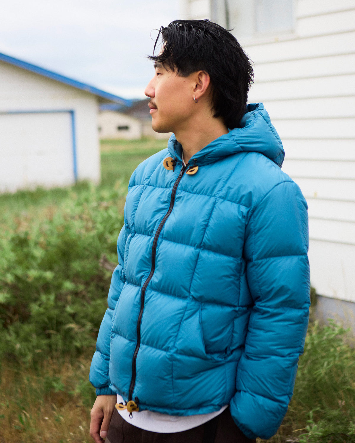 Vibrant blue quilted nylon puffer jacket with hood and tan toggle closures in duck blue hooded sweatshirt style