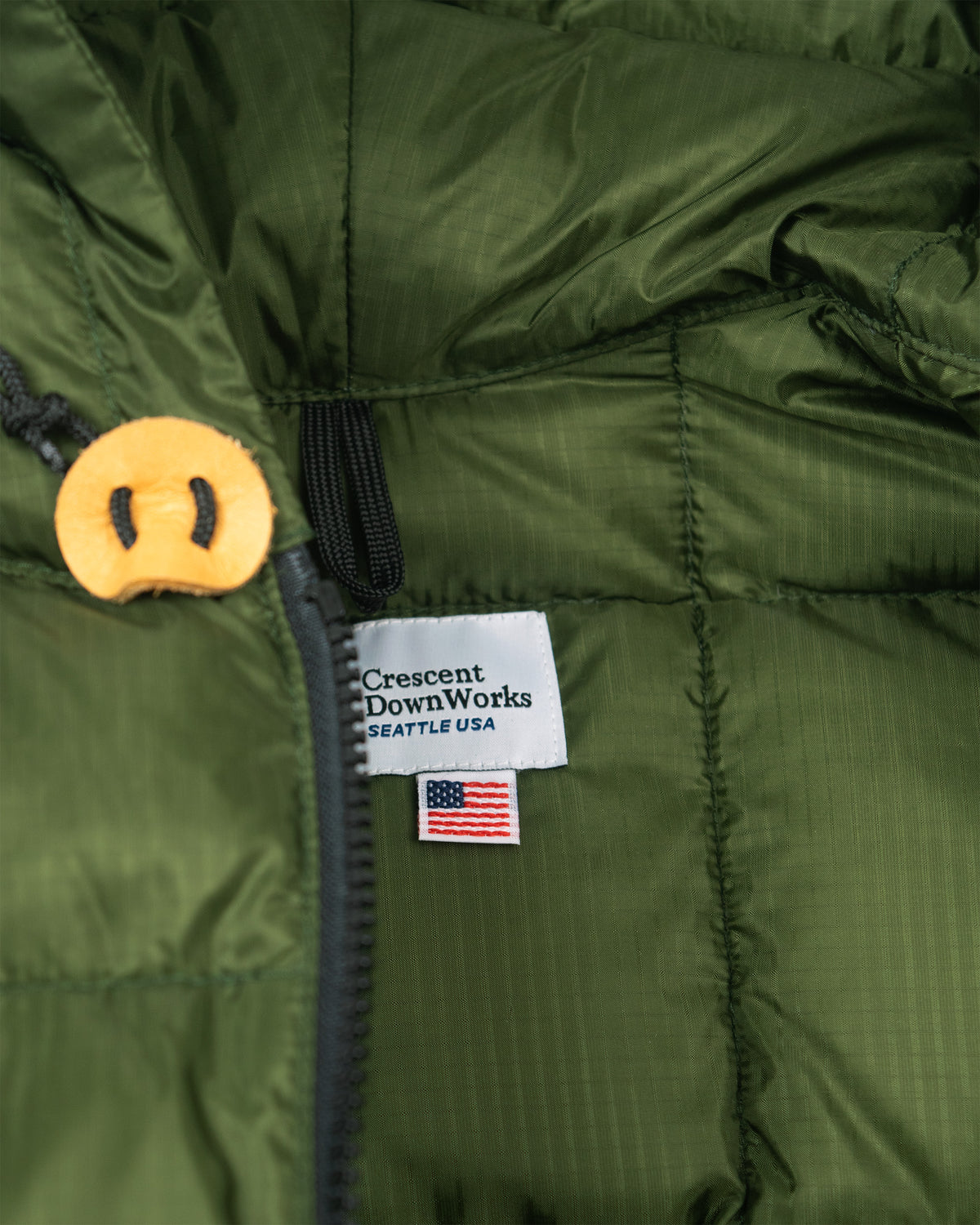 Olive green hooded sweatshirt in ripstop nylon with leather toggle and crescent downworks seattle usa tag