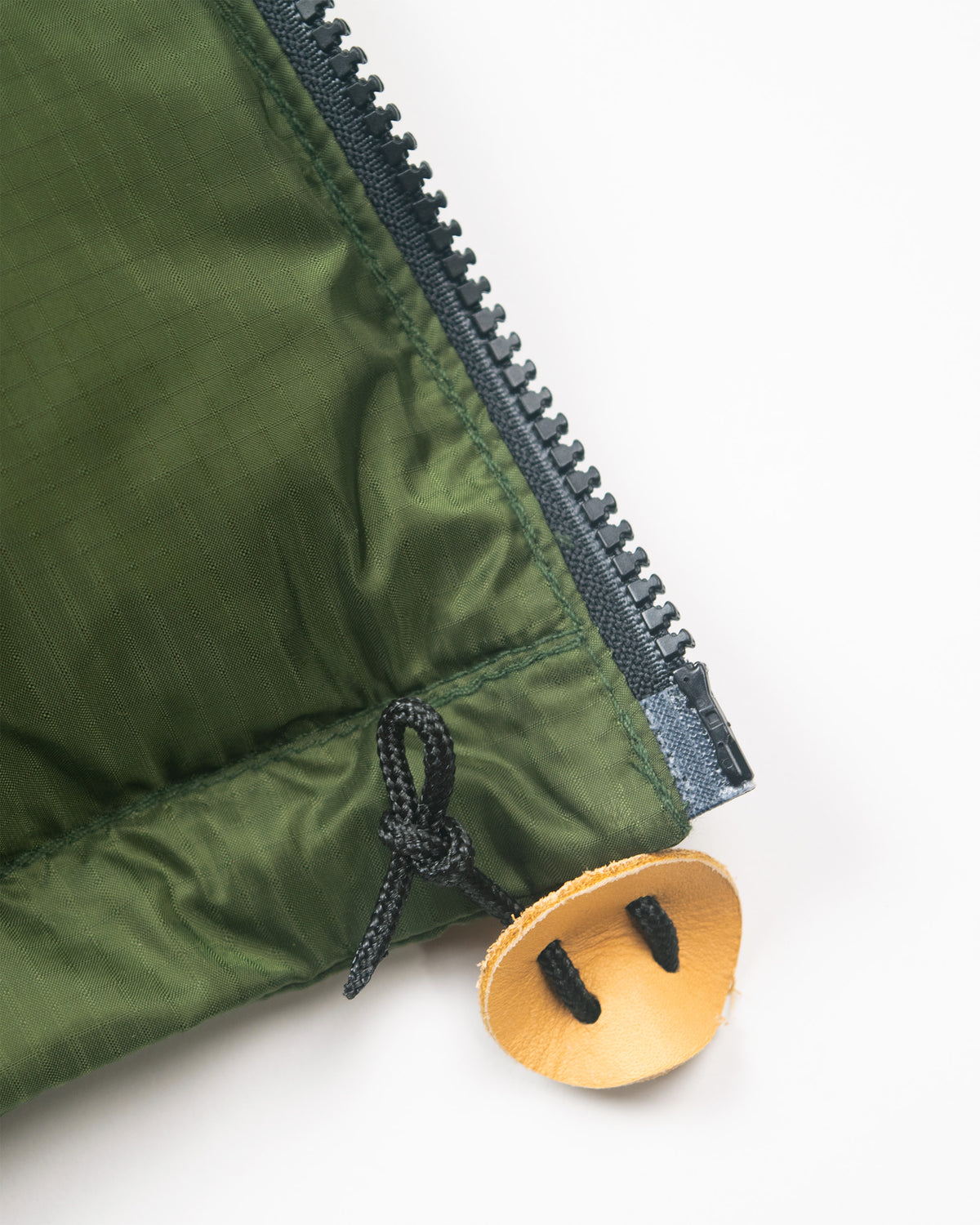 Olive green hooded sweatshirt made of ripstop nylon with black zipper and leather toggles