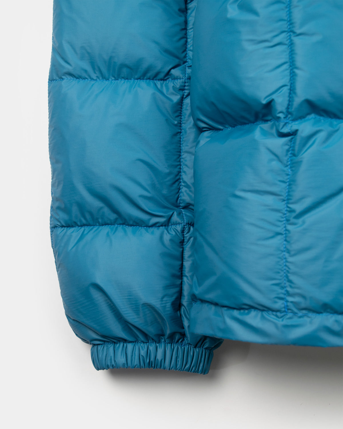 Blue quilted nylon puffer jacket sleeve with elasticated cuff in duck blue hooded sweatshirt design