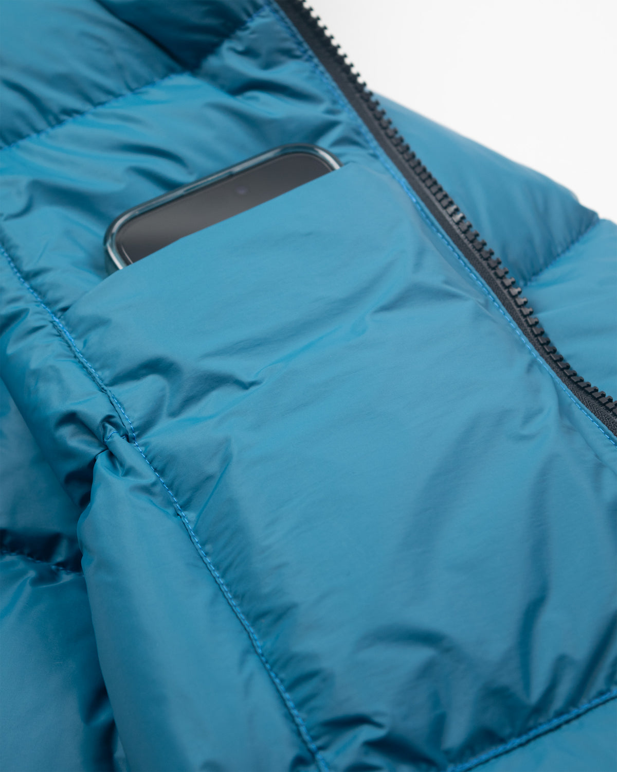A hooded sweatshirt in duck blue nylon with a quilted puffer design and black zipper