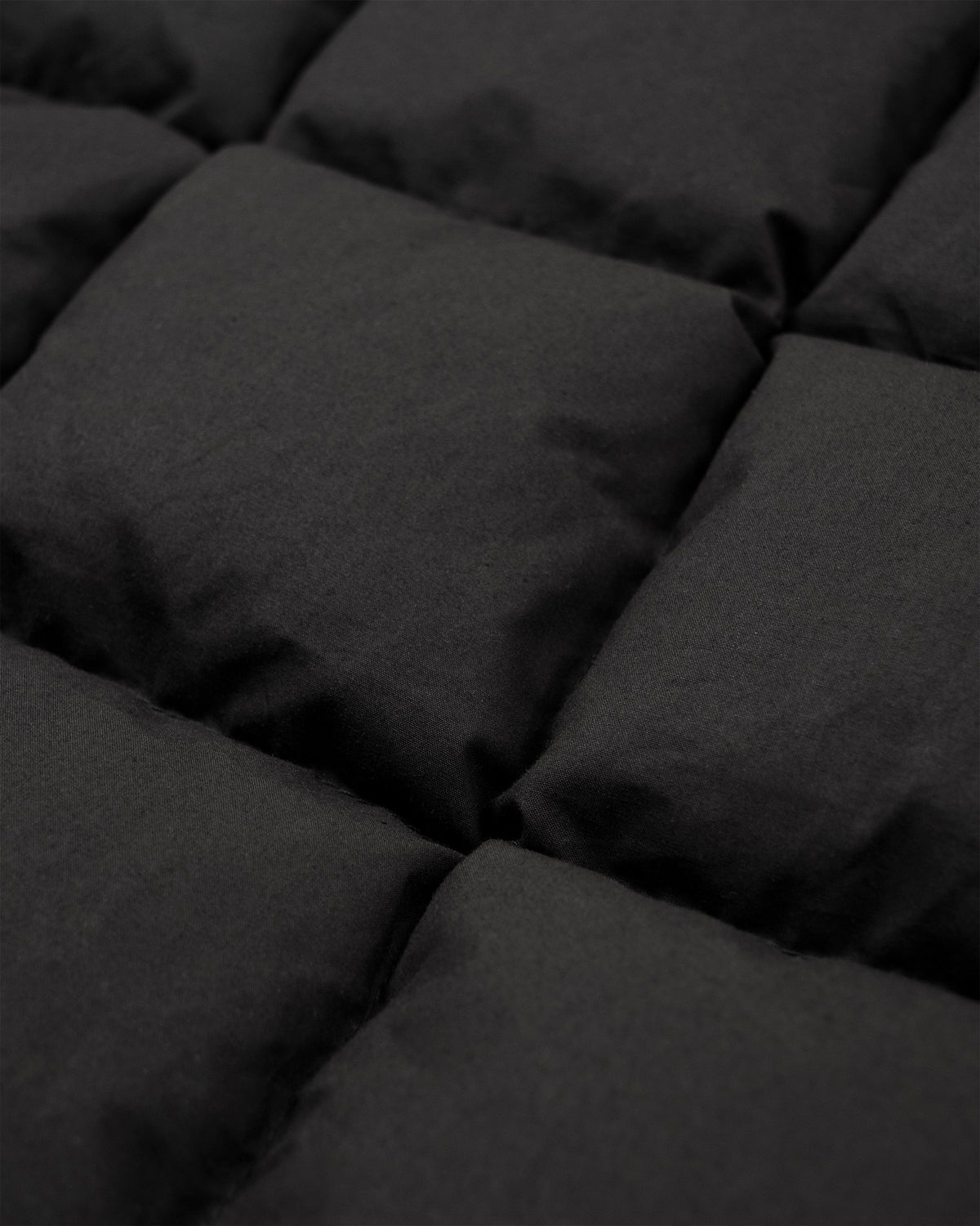 Black hooded sweatshirt made of dry wax cotton with quilted plush comforter texture and square stitched sections