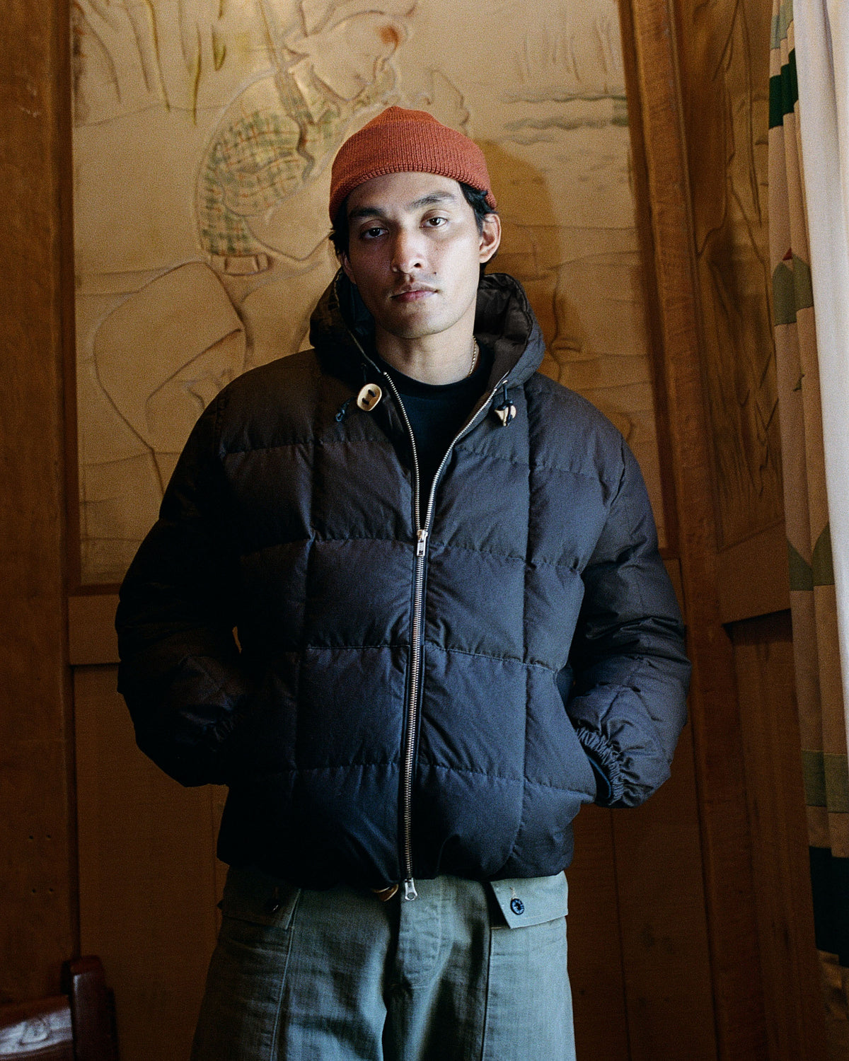 Black quilted puffer jacket with zipper front and button closure made from dry wax cotton material