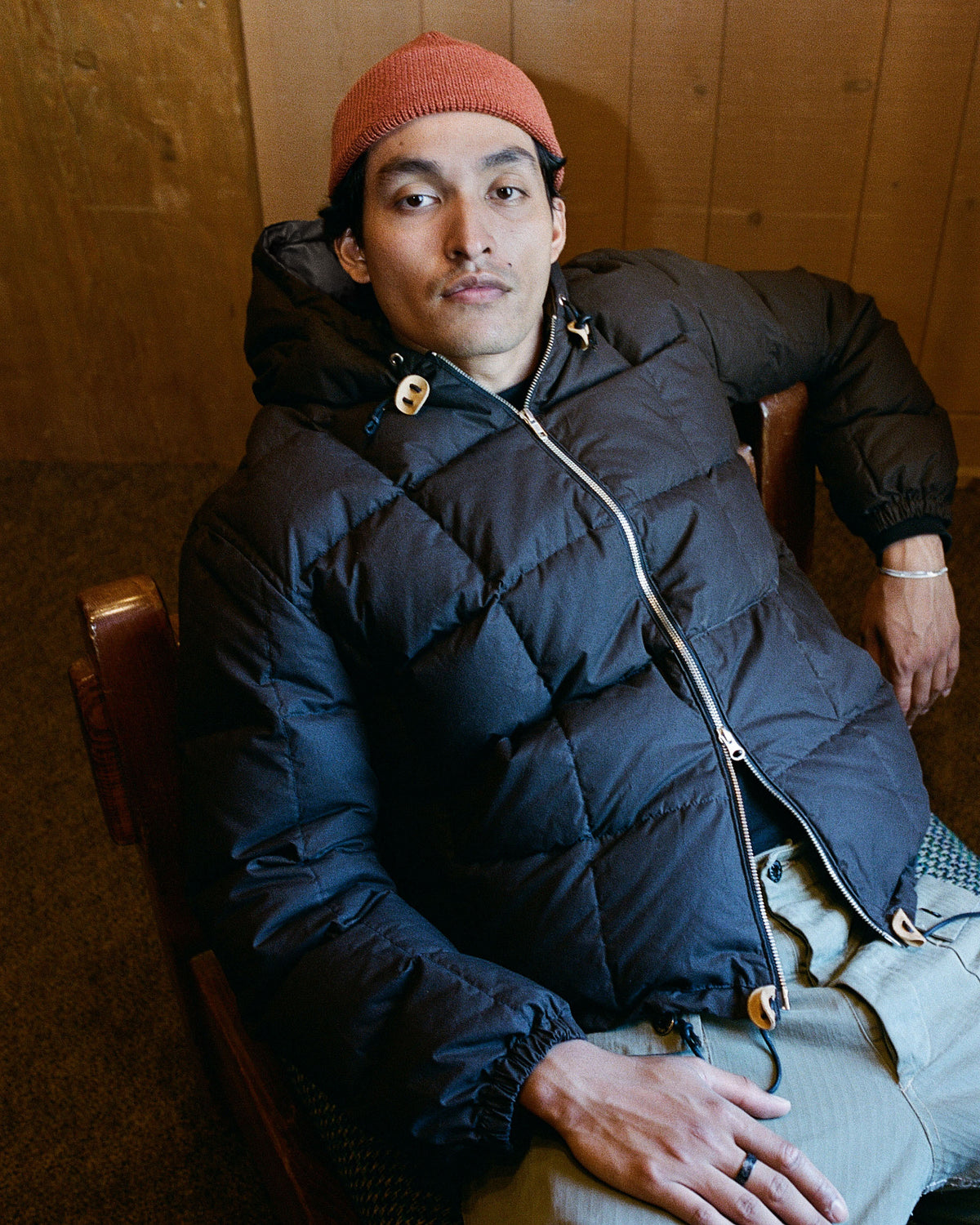 Black quilted puffer jacket with hood and silver zipper made from dry wax cotton