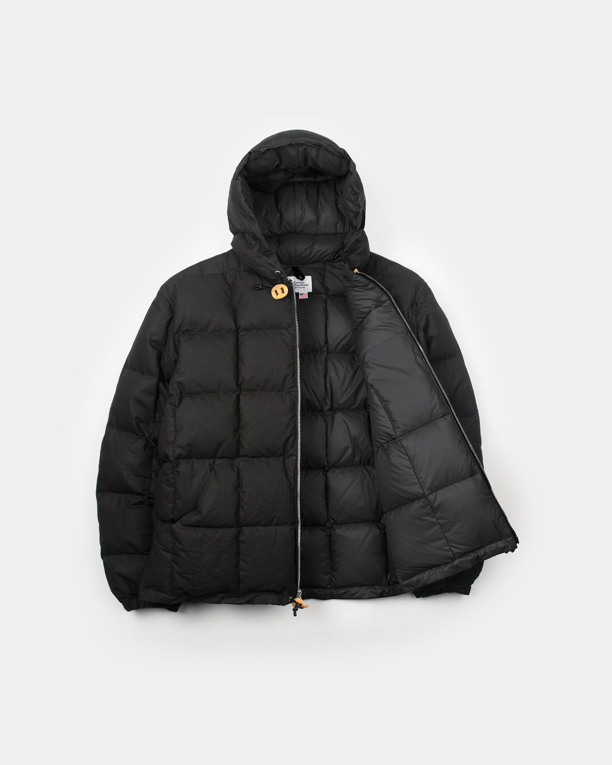 Black quilted puffer jacket with hood and zipper closure made from dry wax cotton for warmth and style