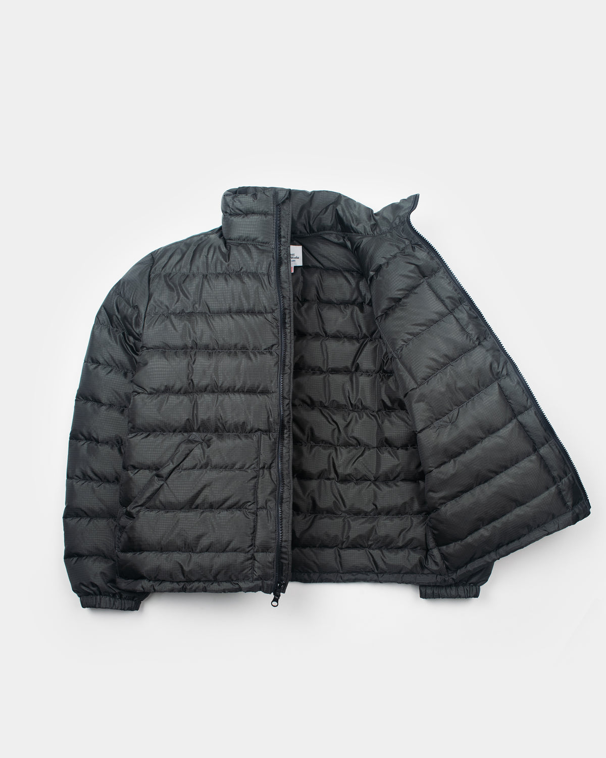 A charcoal Seattle Liner jacket with horizontal quilting, laid flat against a light gray background.