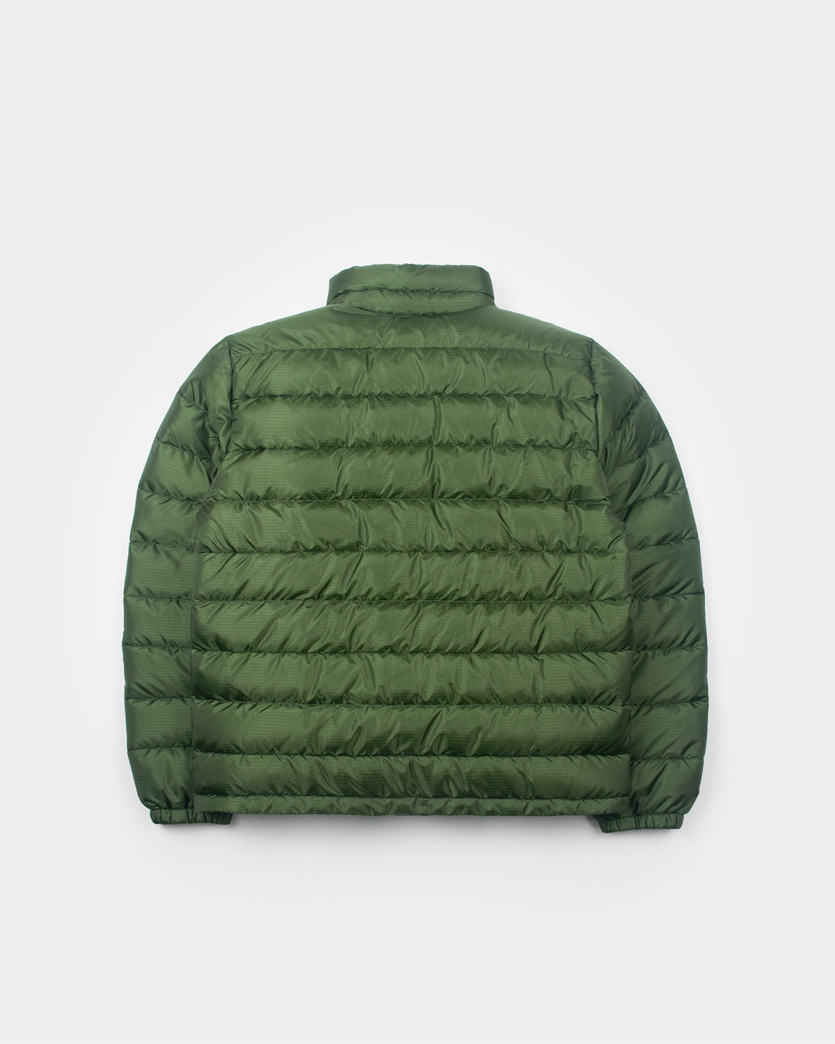 A flat photo a green Seattle Liner jacket with horizontal quilting, against a light gray background.