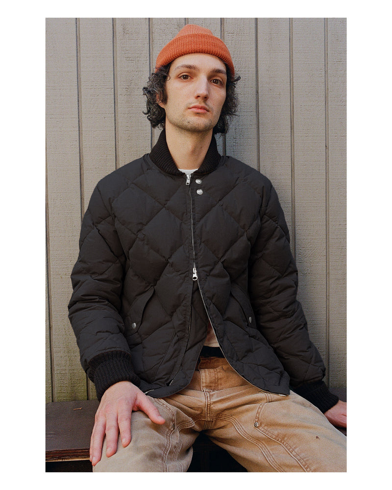 Today Male model sitting outdoors wearing black wax cotton Diagonal Quilt Sweater