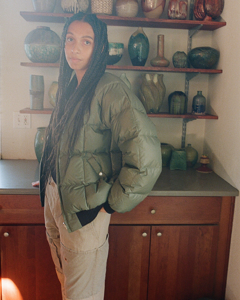 2010 Female Model indoors wearing reversible bomber on olive square quilt side