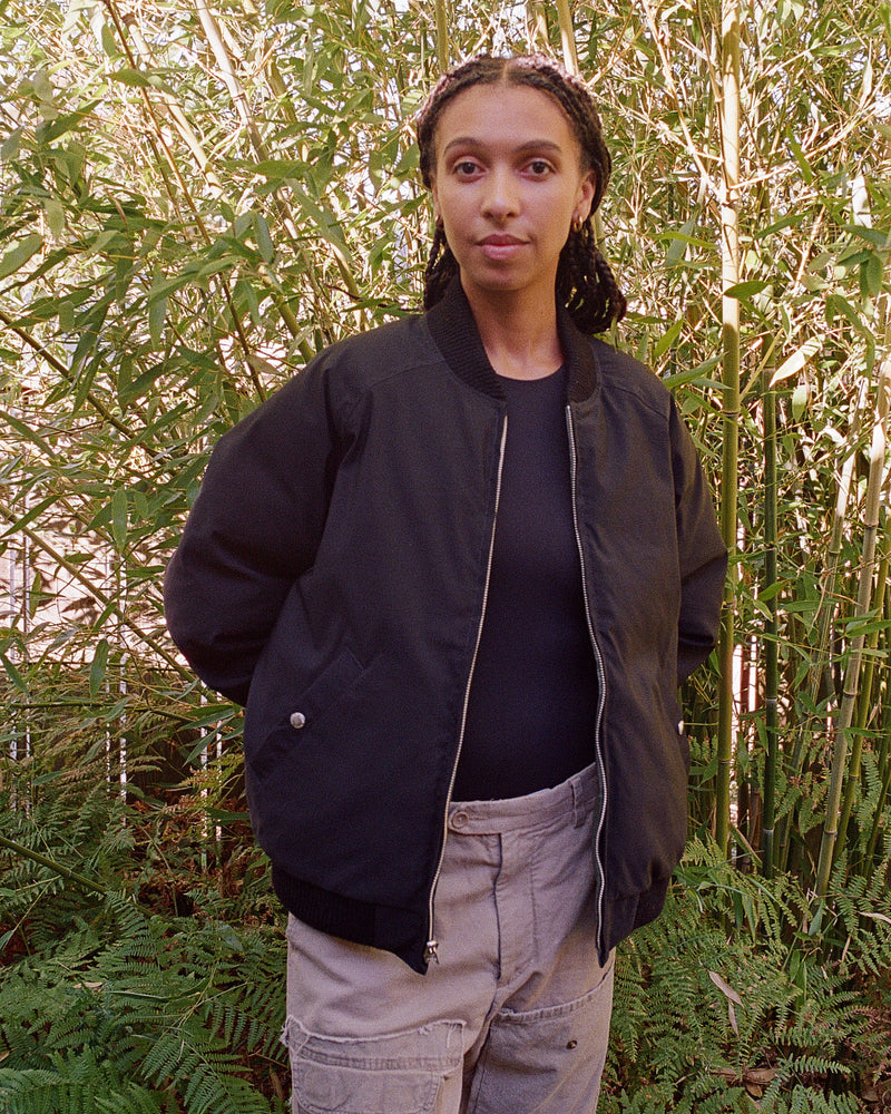 2010 Female Model wearing Reversible Black side of Down Bomber in bamboo outdoors