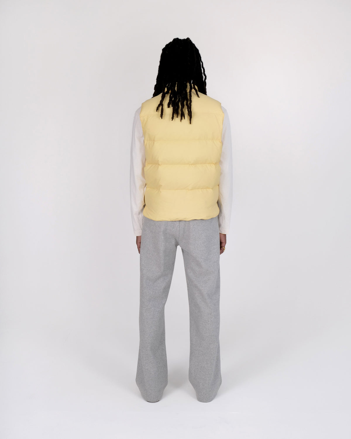 Back view of a model wearing the Crescent Down Works &quot;Sun&quot; colorway of the Down North by Northwest vest. 