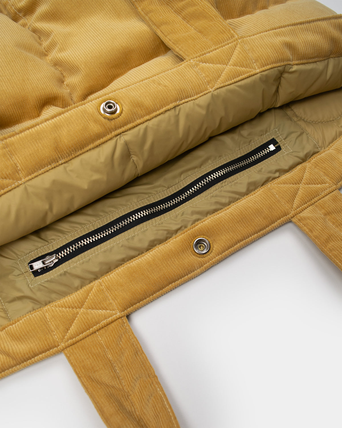 Close-up of a corduroy "corn" yellow corduroy down tote inner zipper. 