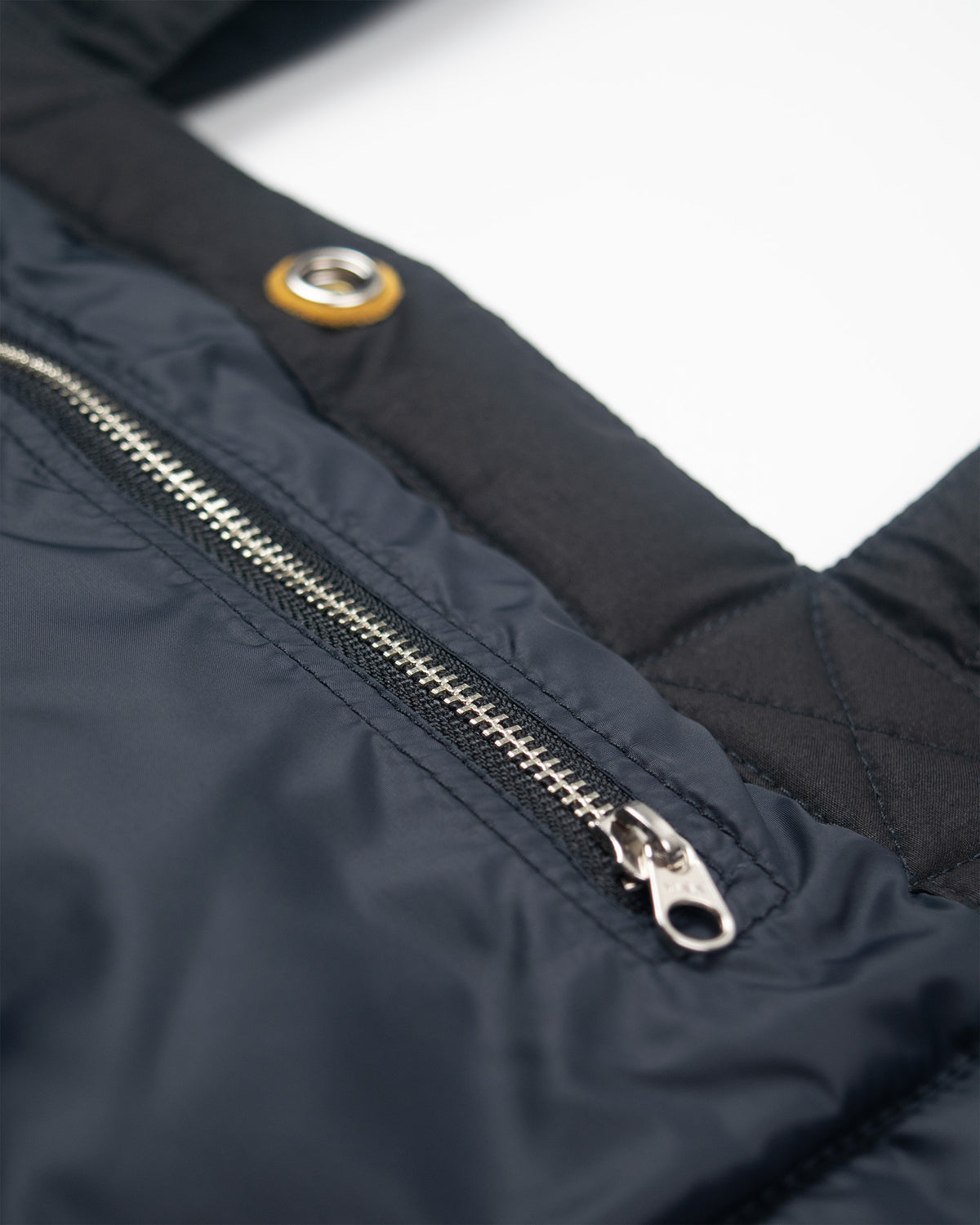Black quilted tote with silver zipper and leather snap reinforcement shown with down dry wax cotton black