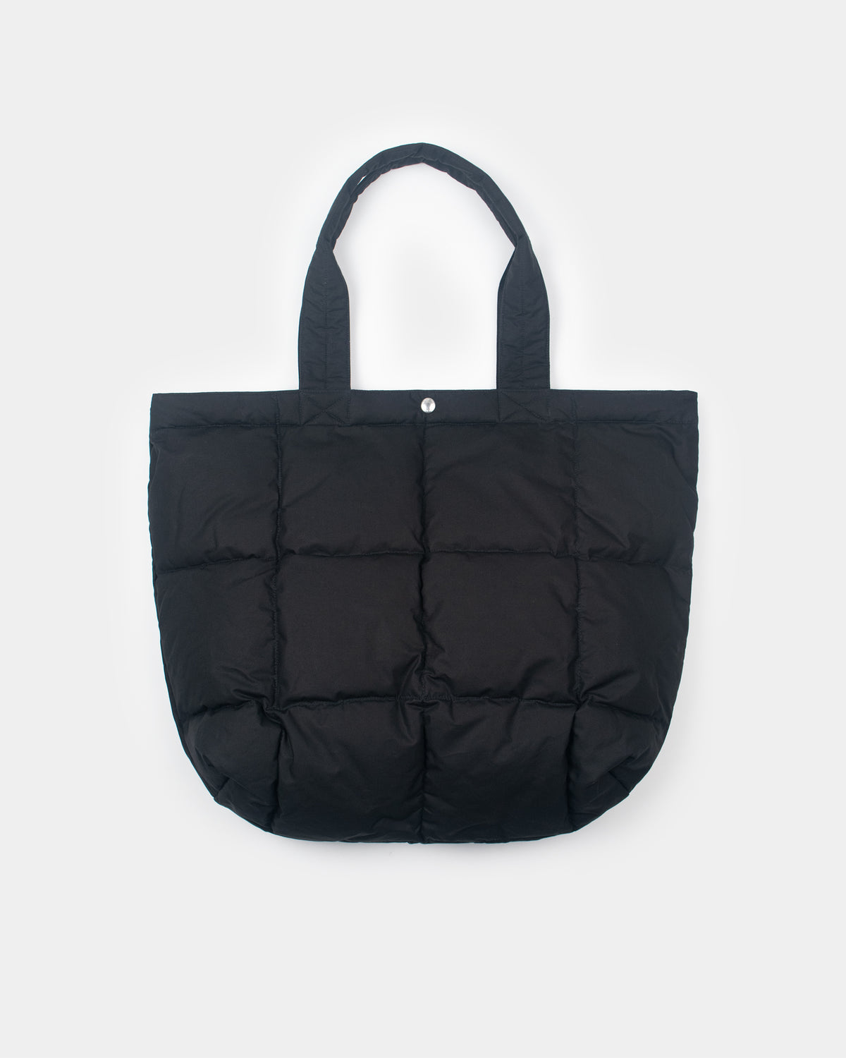 Black quilted puffer down tote bag with fabric handles and single silver snap button made from dry wax cotton