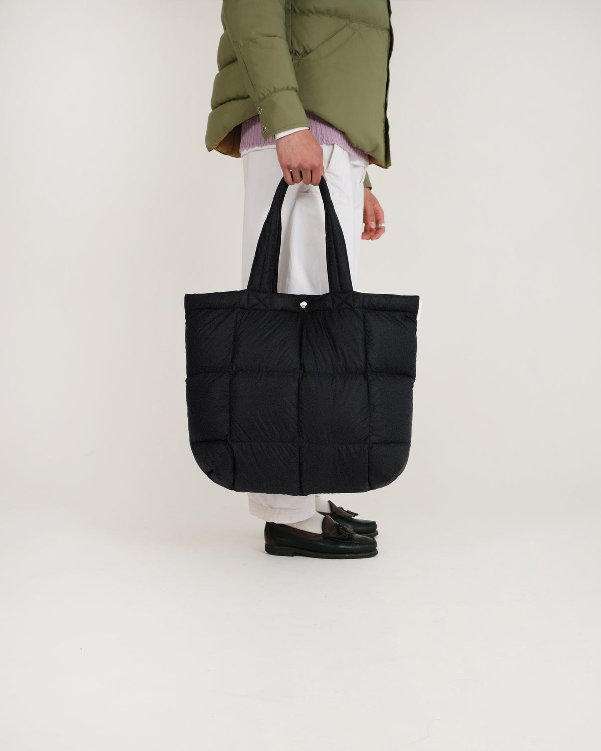 Black quilted puffer tote bag with sturdy handles made of dry wax cotton for durable everyday use